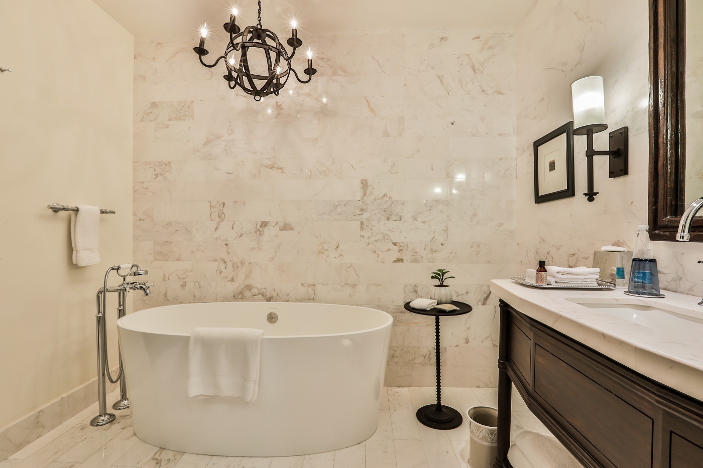 Luxurious marble bathroom with a freestanding tub and elegant chandelier at Banyan Tree Puebla-Urban room king.